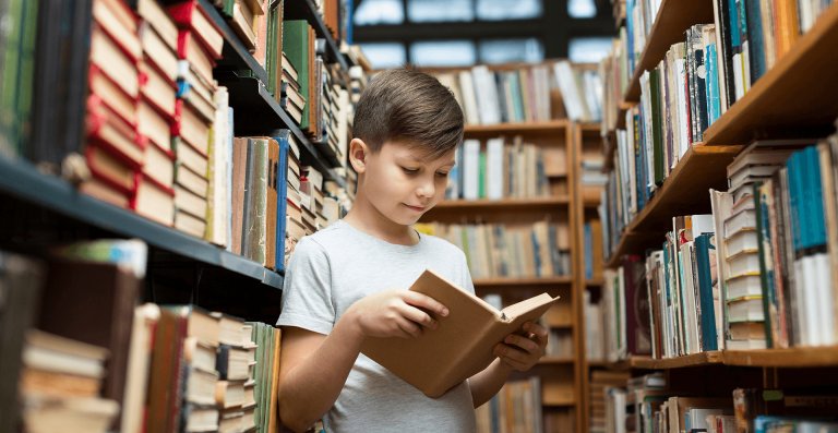 chłopiec czytający w bibliotece