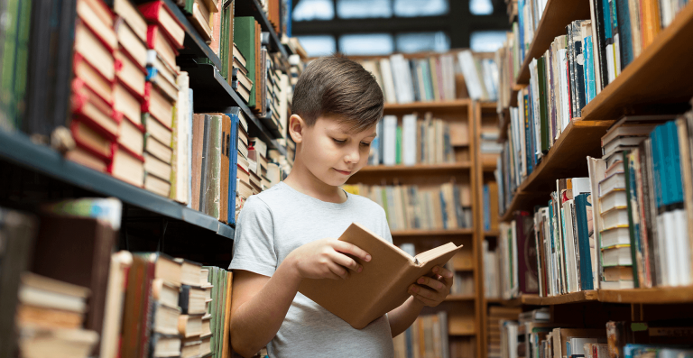 junge liest in der Bibliothek