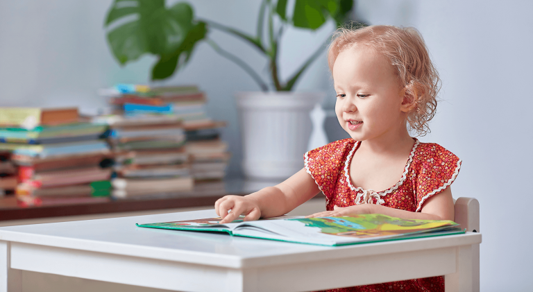 little girl looking at a book