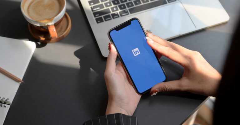 female holding smartphone with linkedin app